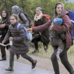 Syrian refugees cross a road with their children while on the run in a forest in Macedonia after illegally crossing Greek-Macedonian border near the city of Gevgelija on April 23, 2016. Some 50,000 people, many of them fleeing the war in Syria, have been stranded in Greece since the closure of the migrant route through the Balkans in February. / AFP PHOTO / JOE KLAMAR